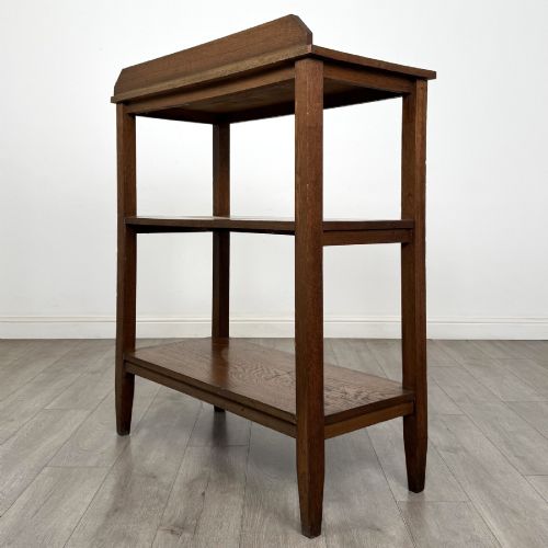 fig 5. An antique Edwardian dark oak buffet featuring three open rectangular shelves supported by straight tapered legs.