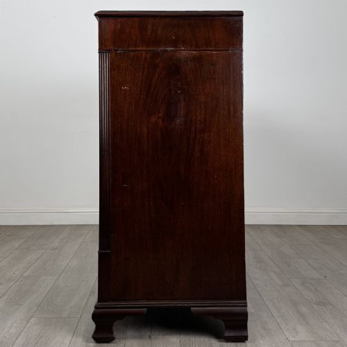 fig 2. An 18th-century Georgian mahogany chest of drawers featuring inlaid stringing along the top frieze, two short drawers above three long drawers, brass swan-neck handles, fluted pilasters, and bracket feet.