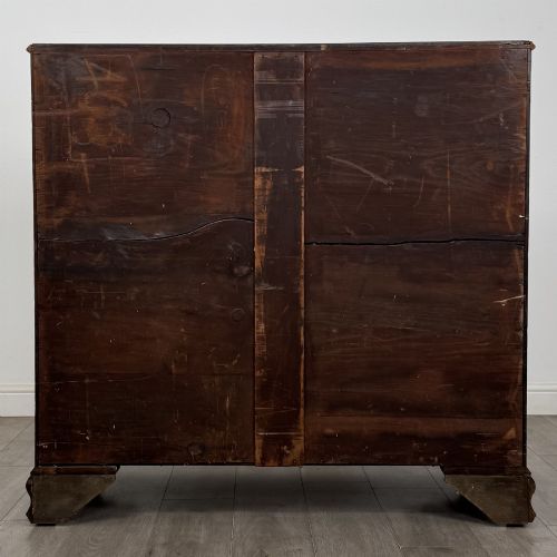 fig 4. An 18th-century Georgian mahogany chest of drawers featuring inlaid stringing along the top frieze, two short drawers above three long drawers, brass swan-neck handles, fluted pilasters, and bracket feet.