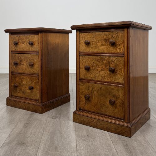 fig 2. A pair of Victorian burr walnut bedside cabinets featuring three drawers each with turned wooden knobs and a plinth base.