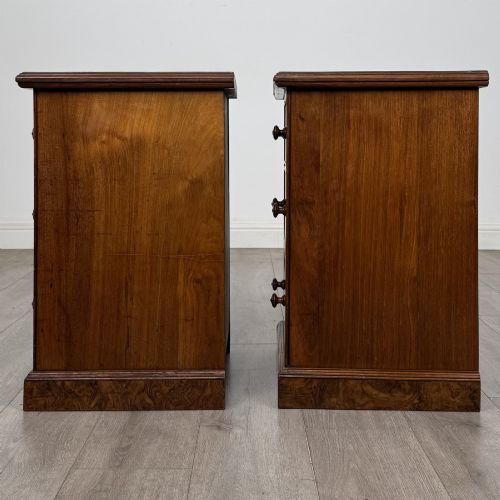 fig 3. A pair of Victorian burr walnut bedside cabinets featuring three drawers each with turned wooden knobs and a plinth base.