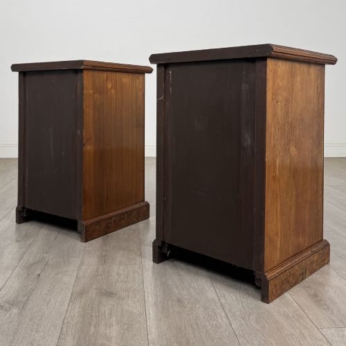 fig 6. A pair of Victorian burr walnut bedside cabinets featuring three drawers each with turned wooden knobs and a plinth base.