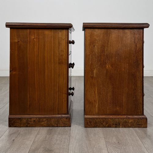 fig 7. A pair of Victorian burr walnut bedside cabinets featuring three drawers each with turned wooden knobs and a plinth base.