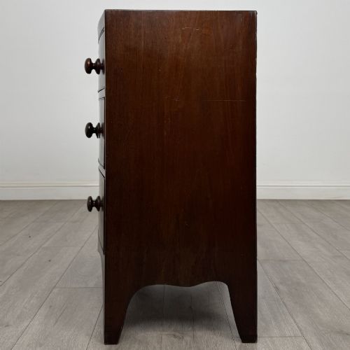 fig 2. A 19th-century dark mahogany bow front chest of drawers featuring two short drawers above two long drawers with turned wooden handles and bracket feet.