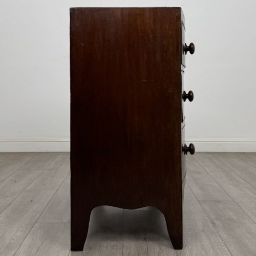 fig 6. A 19th-century dark mahogany bow front chest of drawers featuring two short drawers above two long drawers with turned wooden handles and bracket feet.