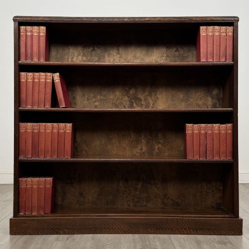 fig 1. A dark oak open bookcase featuring four tier adjustable shelves and carved moulding along the top frieze.