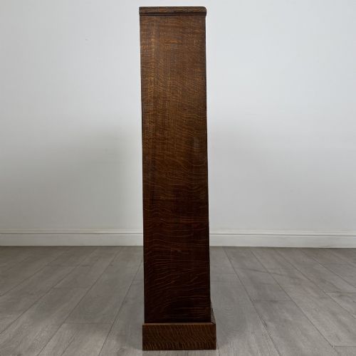 fig 7. A dark oak open bookcase featuring four tier adjustable shelves and carved moulding along the top frieze.