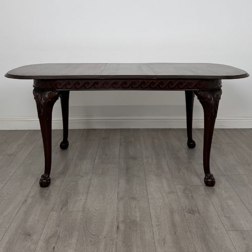 fig 1. An Edwardian mahogany extending dining table featuring a carved frieze and cabriole legs terminating in ball-and-claw feet.