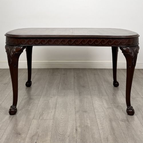 fig 2. An Edwardian mahogany extending dining table featuring a carved frieze and cabriole legs terminating in ball-and-claw feet.