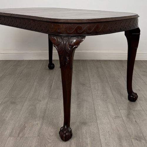 fig 3. An Edwardian mahogany extending dining table featuring a carved frieze and cabriole legs terminating in ball-and-claw feet.