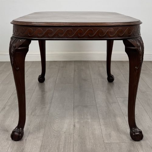 fig 4. An Edwardian mahogany extending dining table featuring a carved frieze and cabriole legs terminating in ball-and-claw feet.