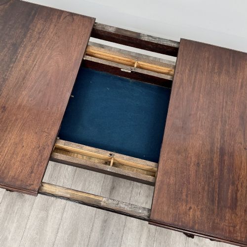fig 7. An Edwardian mahogany extending dining table featuring a carved frieze and cabriole legs terminating in ball-and-claw feet.