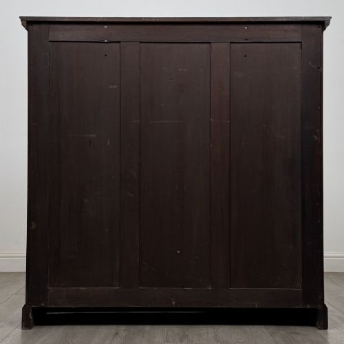 fig 5. An Edwardian dark mahogany open bookcase featuring three frieze drawers with brass drop handles and three adjustable wooden shelves above a plinth base.
