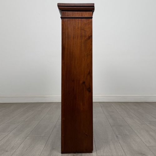fig 3. A dark brown Victorian pine open bookcase featuring adjustable shelving, reeded side pilasters, and a shaped apron at the base.
