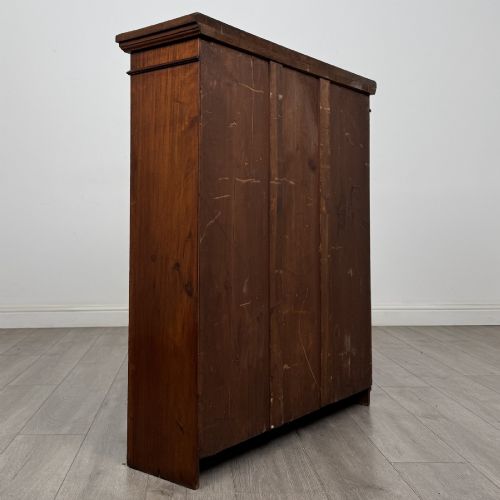 fig 4. A dark brown Victorian pine open bookcase featuring adjustable shelving, reeded side pilasters, and a shaped apron at the base.