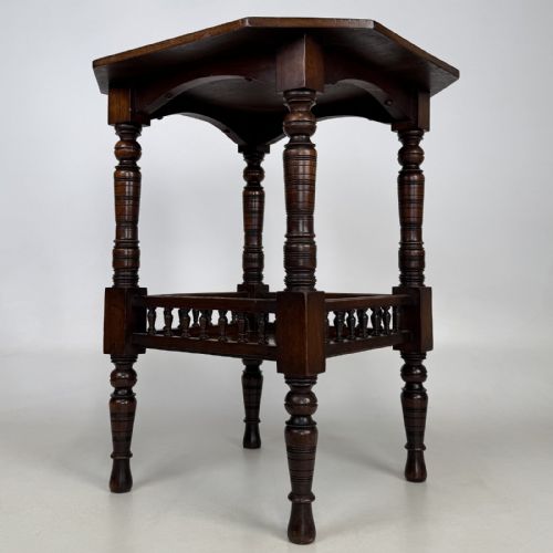 fig 3. A dark walnut Victorian Aesthetic side table featuring an octagonal top, turned legs, and a lower shelf enclosed by a turned spindle gallery.