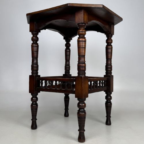 fig 5. A dark walnut Victorian Aesthetic side table featuring an octagonal top, turned legs, and a lower shelf enclosed by a turned spindle gallery.