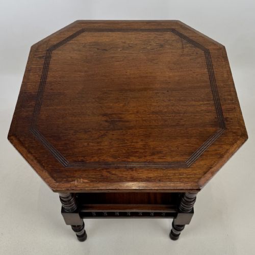 fig 6. A dark walnut Victorian Aesthetic side table featuring an octagonal top, turned legs, and a lower shelf enclosed by a turned spindle gallery.