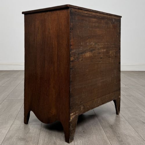 fig 3. A 19th-century oak chest of drawers featuring four graduated drawers with ornate brass backplate drop handles, keyhole escutcheons, and bracket feet.
