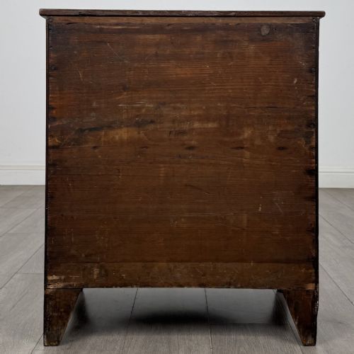 fig 4. A 19th-century oak chest of drawers featuring four graduated drawers with ornate brass backplate drop handles, keyhole escutcheons, and bracket feet.
