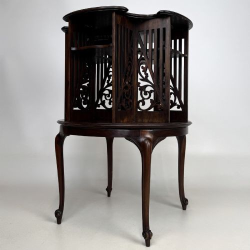fig 3. An Edwardian dark mahogany revolving bookcase with pierced foliage fretwork side panels and cabriole legs.