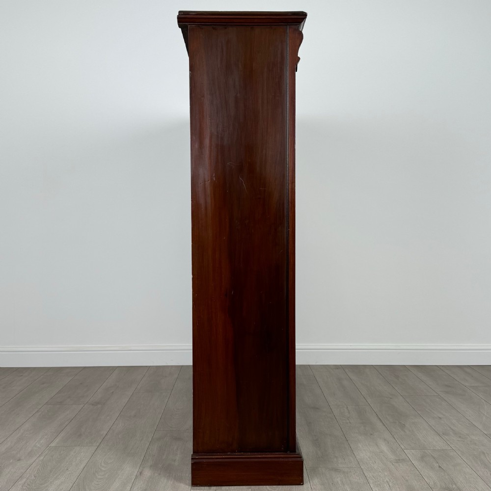 A front-facing view of a large, dark brown mahogany open bookcase featuring a central vertical divider and multiple fixed shelves. View VII