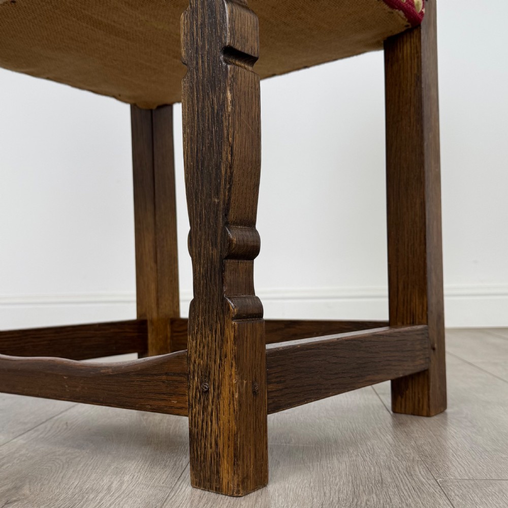 A set of fourteen dark oak dining chairs with red and cream fleur-de-lis patterned upholstery and brass stud trim. View VII