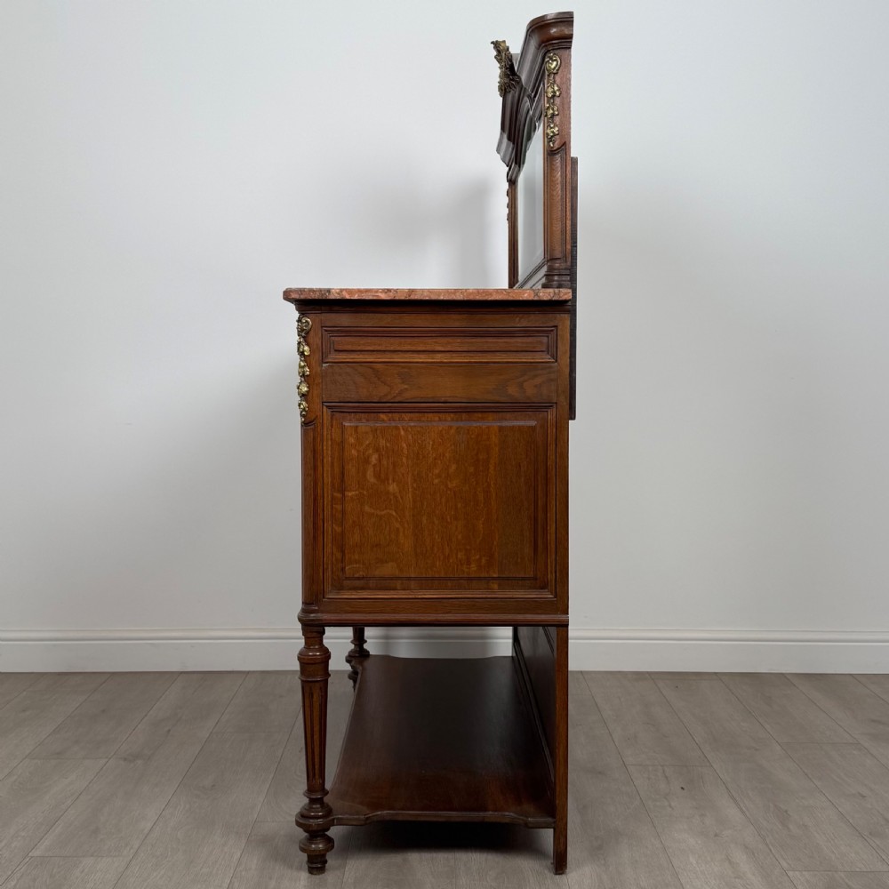 A pair of 19th-century French dark wood cabinets featuring pink marble tops, mirrored upper backs, gilded metal mounts, and lower open shelves. View V
