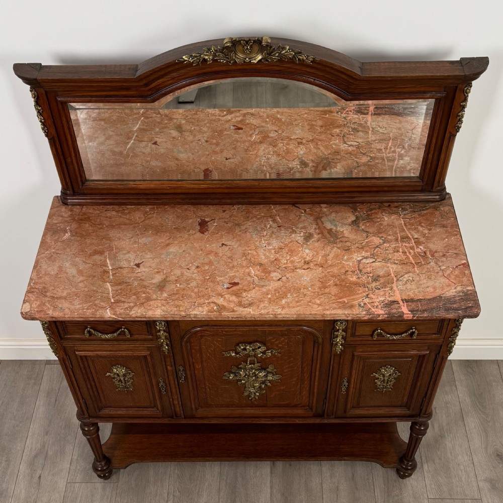 A pair of 19th-century French dark wood cabinets featuring pink marble tops, mirrored upper backs, gilded metal mounts, and lower open shelves. View XI