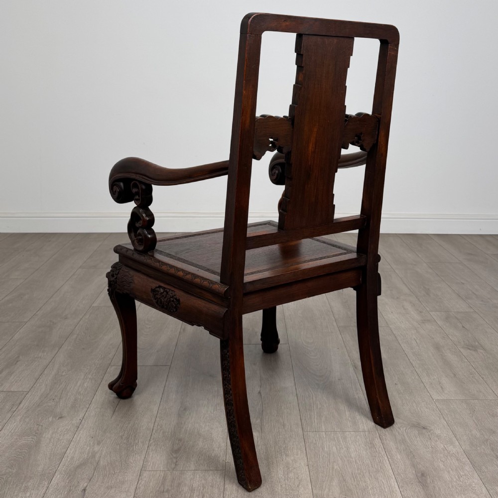 A dark carved rosewood dining suite featuring a rectangular table with carved cabriole legs accompanied by six splat-back chairs including two armchairs. View X