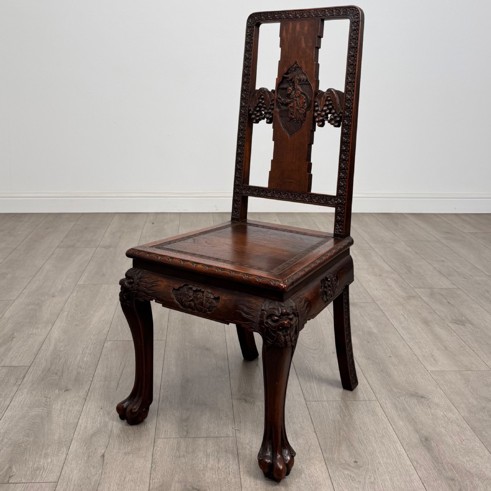 A dark carved rosewood dining suite featuring a rectangular table with carved cabriole legs accompanied by six splat-back chairs including two armchairs. View XI