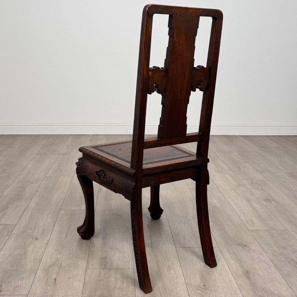 A dark carved rosewood dining suite featuring a rectangular table with carved cabriole legs accompanied by six splat-back chairs including two armchairs. View XII
