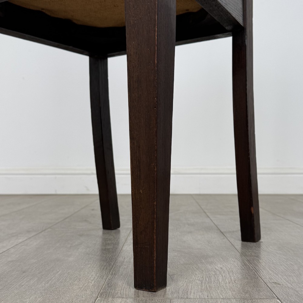 Dark oak trestle dining table paired with six matching carved oak chairs with dark leather seats. View VIII