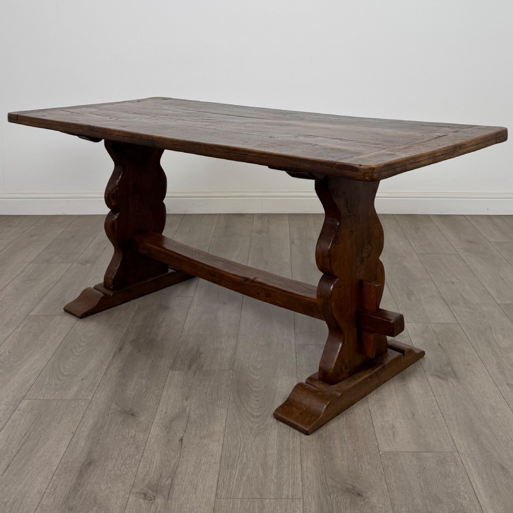 Dark oak trestle dining table paired with six matching carved oak chairs with dark leather seats. View XI