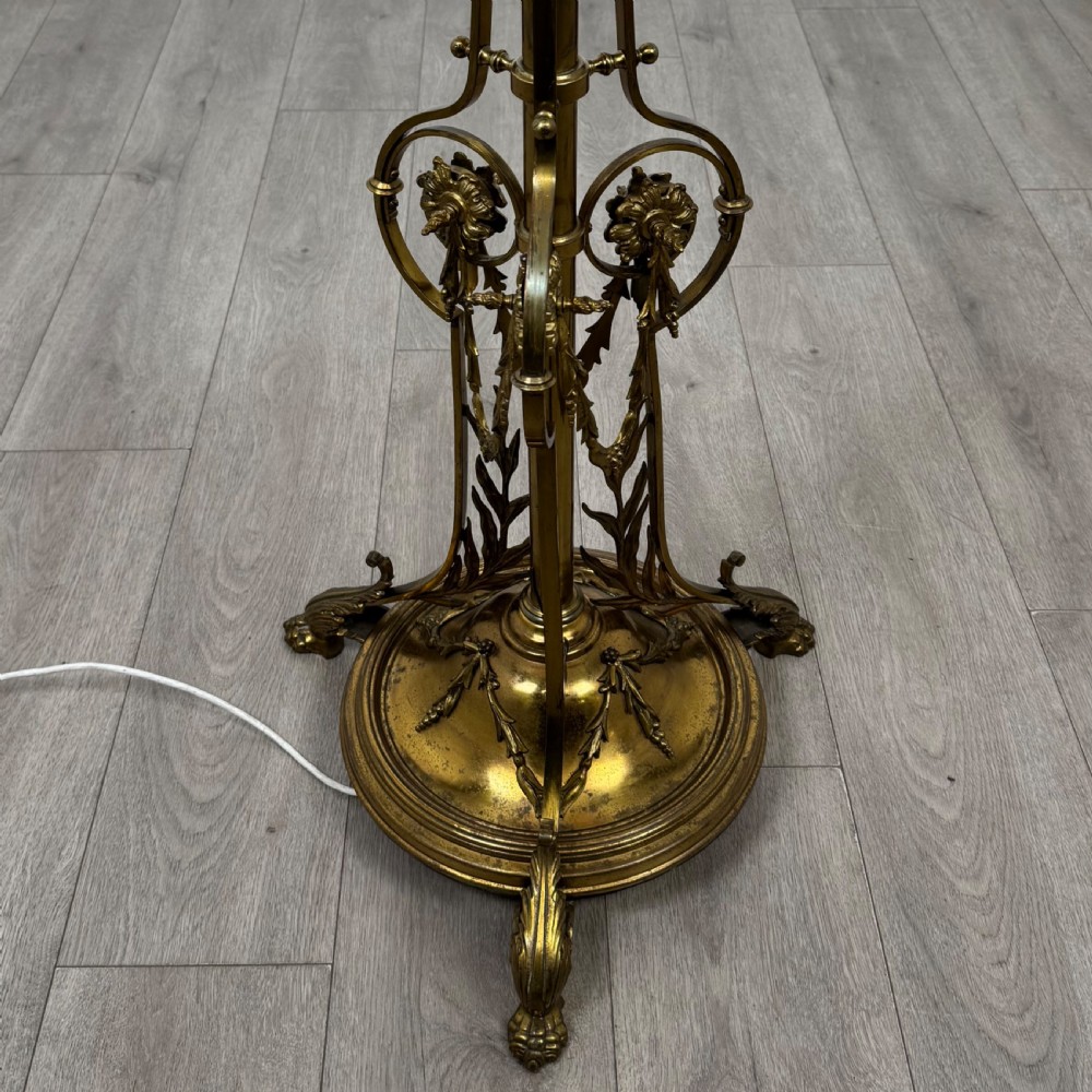 An antique 19th-century brass floor standing lamp featuring an ornate cast base with claw feet and a pink fringed shade. View VI