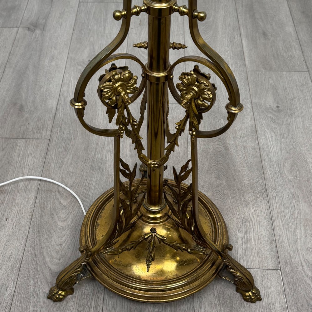 An antique 19th-century brass floor standing lamp featuring an ornate cast base with claw feet and a pink fringed shade. View VIII