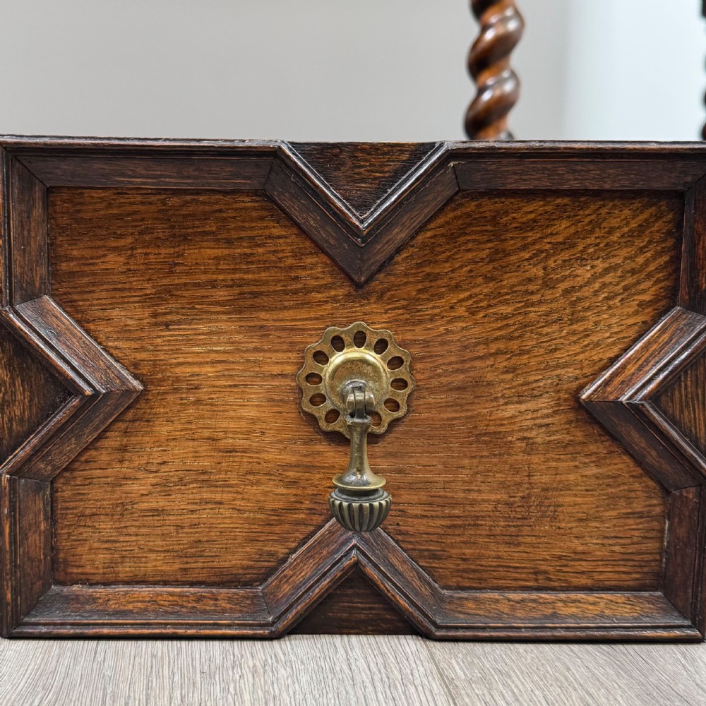 A 20th-century Jacobean style golden oak sideboard featuring geometric moulding, central drawers, cupboard doors, and barley twist legs. View XII