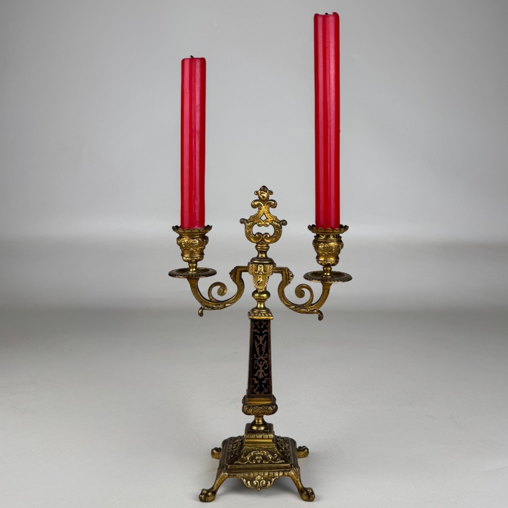 A pair of 19th-century French brass candelabra featuring ornate scrollwork arms and dark enamel inlaid details. View III