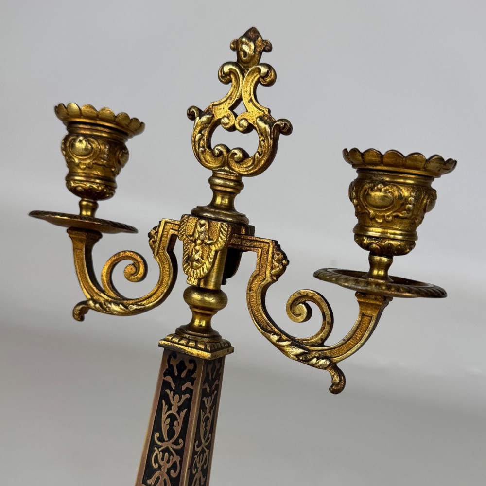 A pair of 19th-century French brass candelabra featuring ornate scrollwork arms and dark enamel inlaid details. View V