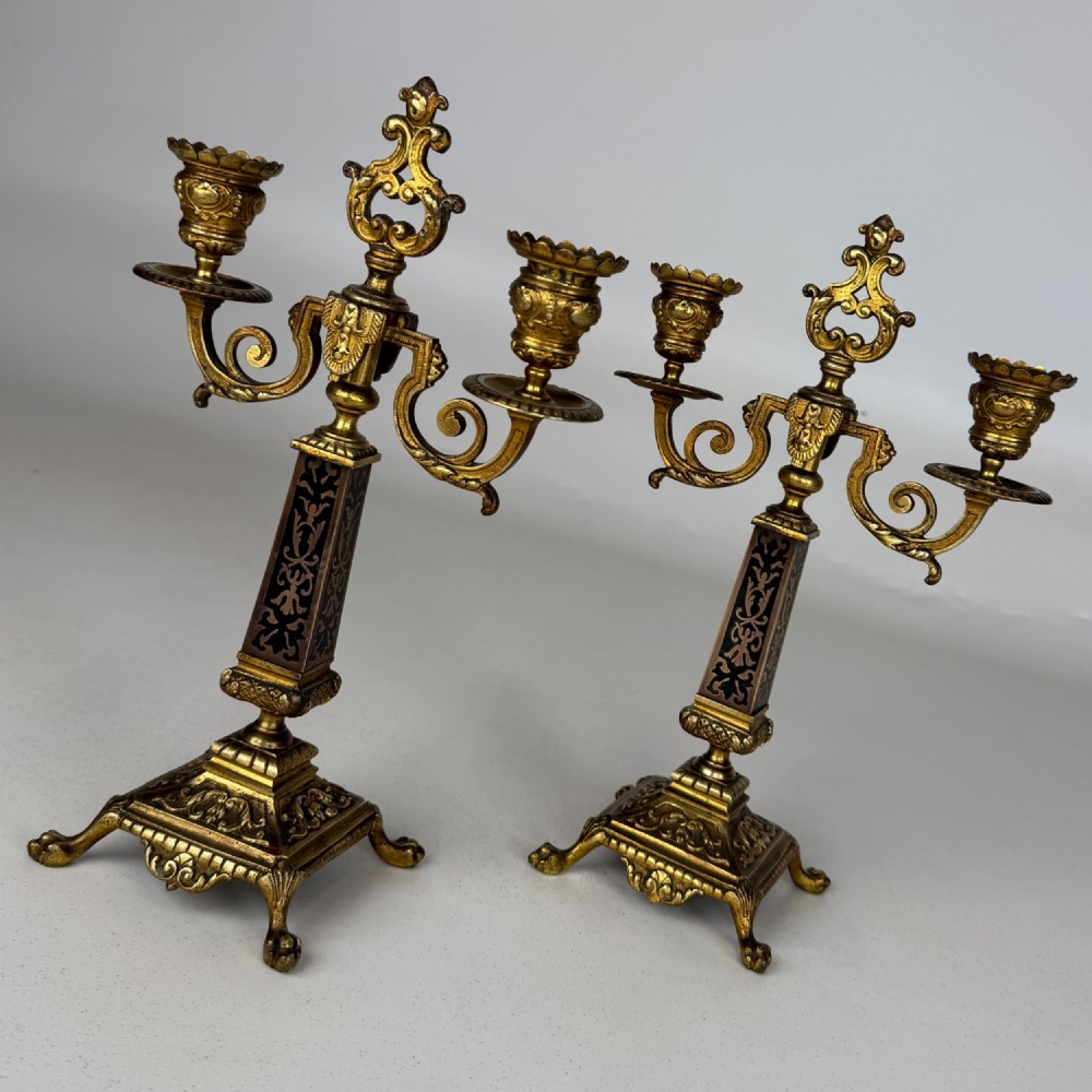 A pair of 19th-century French brass candelabra featuring ornate scrollwork arms and dark enamel inlaid details. View VII