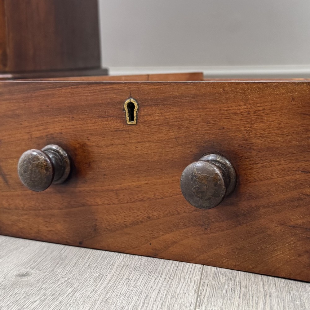 A 19th-century Victorian mahogany Dickens desk featuring a twin-pedestal design, raised superstructure with drawers and spindle gallery, slant writing surface, turned timber knobs, and plinth bases. View XIII