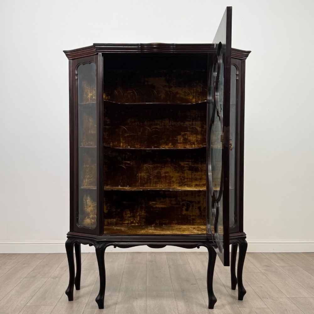 A dark mahogany display cabinet featuring glazed panels, detailed carved fretwork on the central door, and cabriole legs. View II