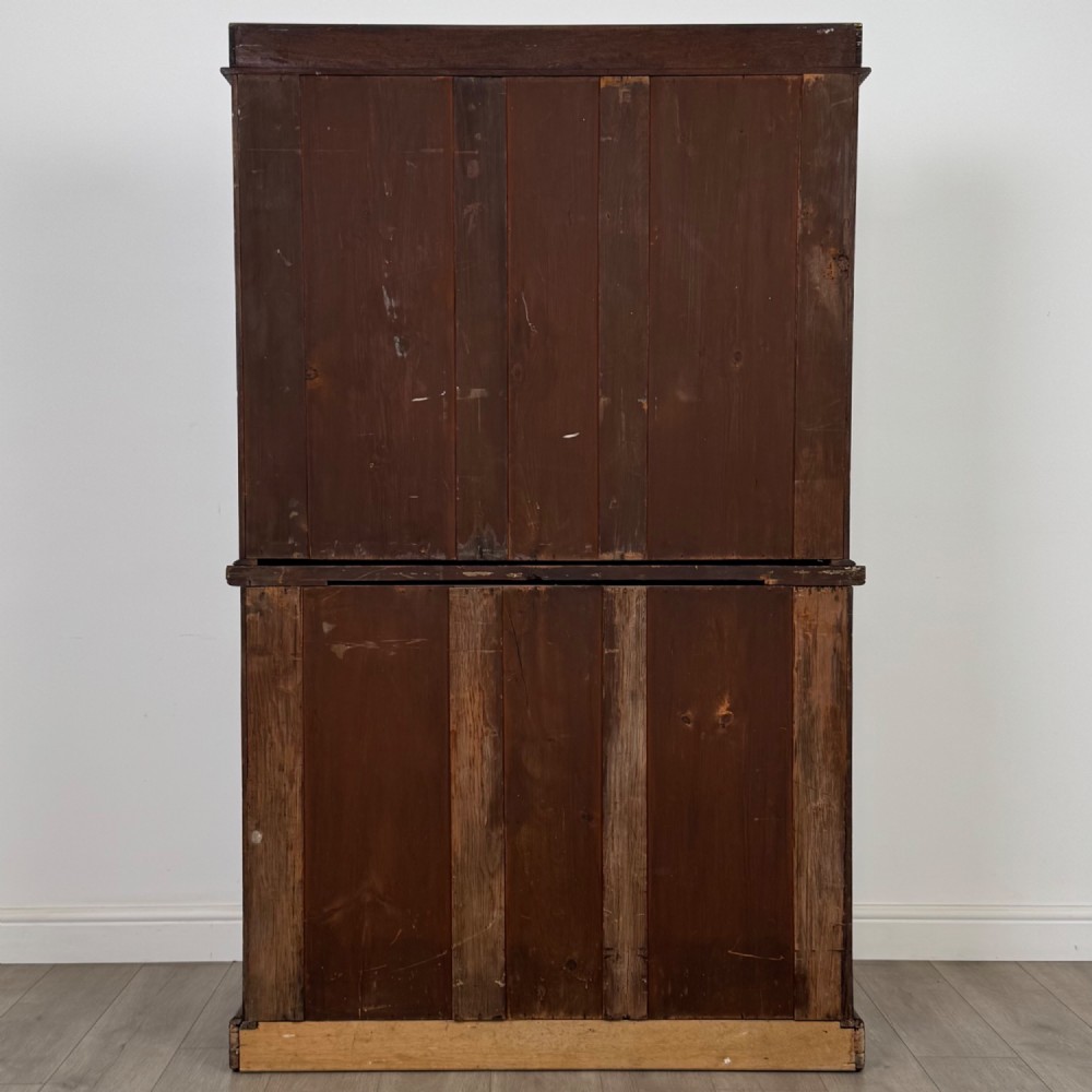 A 19th-century Victorian mahogany bookcase featuring a glazed upper display cabinet with carved corbels above a two-door solid cupboard base. View VII
