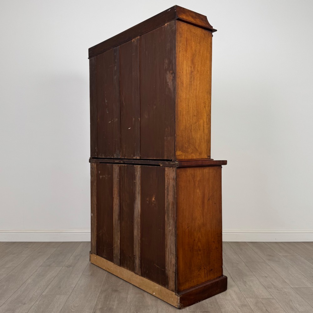 A 19th-century Victorian mahogany bookcase featuring a glazed upper display cabinet with carved corbels above a two-door solid cupboard base. View VIII