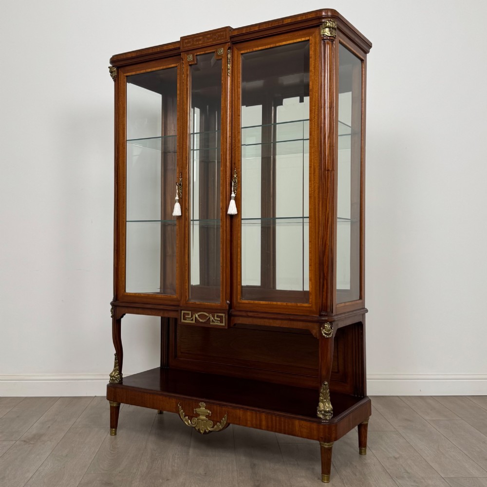 A nineteenth-century French mahogany glazed display cabinet featuring gilt-bronze mounts, glass shelving, and an open lower tier. View III