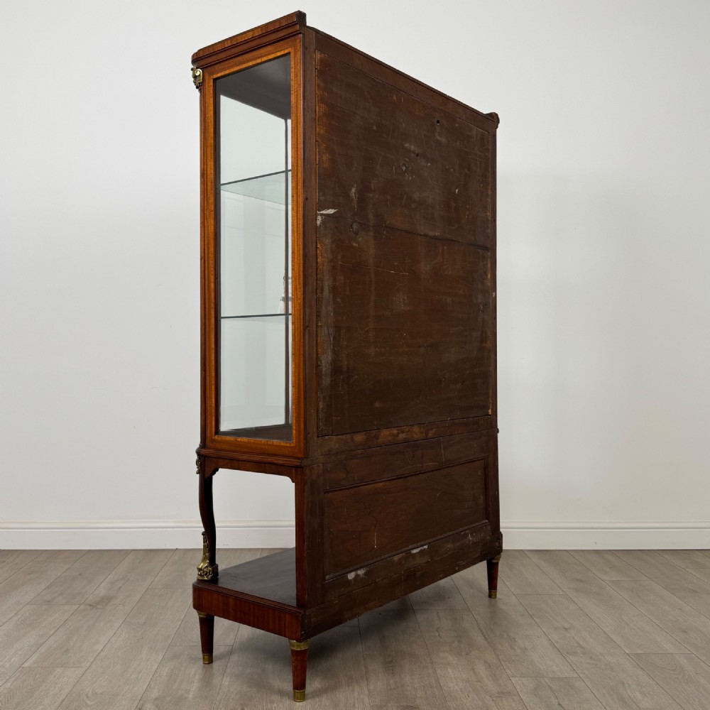 A nineteenth-century French mahogany glazed display cabinet featuring gilt-bronze mounts, glass shelving, and an open lower tier. View V