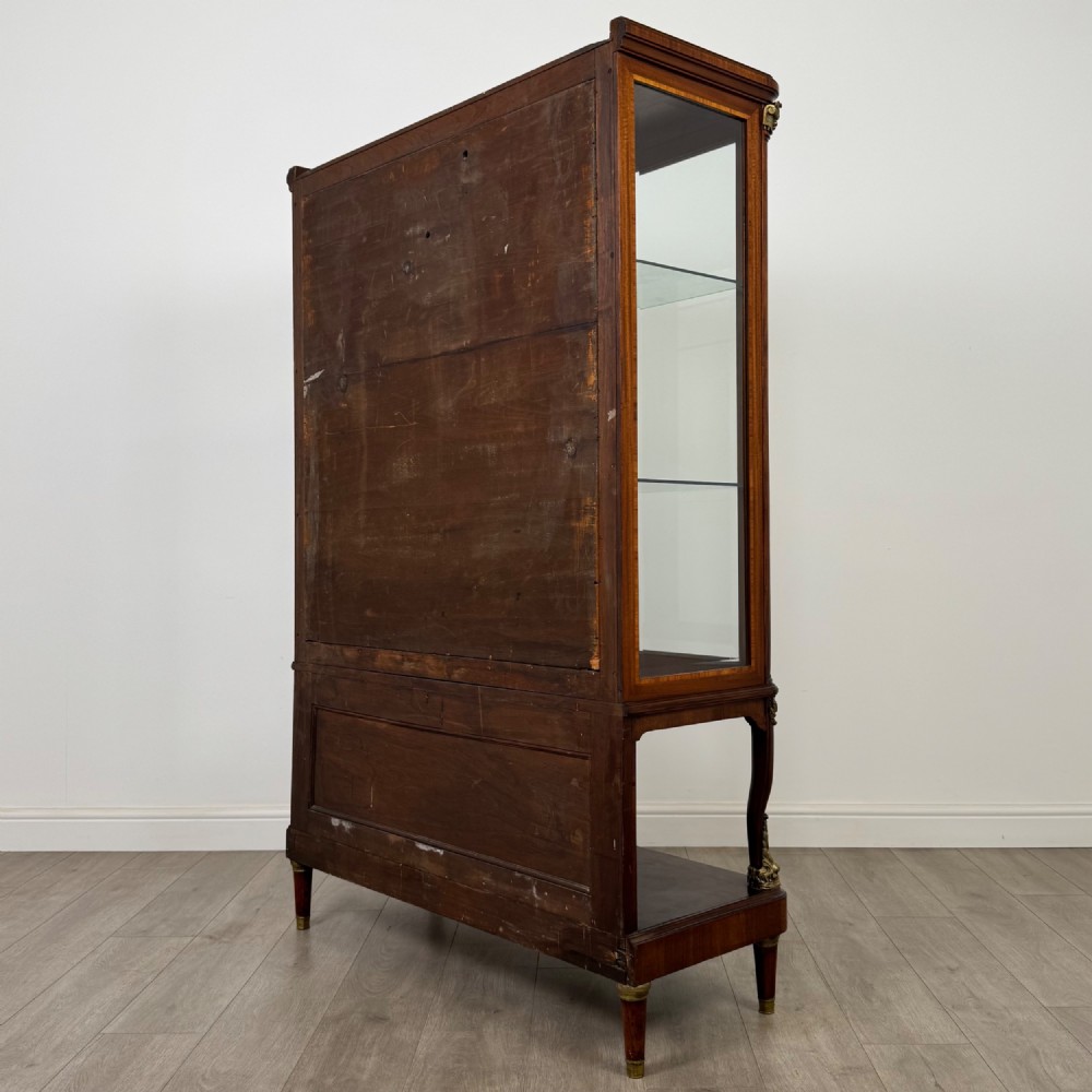 A nineteenth-century French mahogany glazed display cabinet featuring gilt-bronze mounts, glass shelving, and an open lower tier. View VII