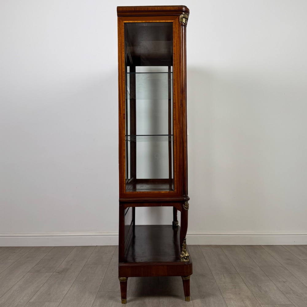 A nineteenth-century French mahogany glazed display cabinet featuring gilt-bronze mounts, glass shelving, and an open lower tier. View VIII