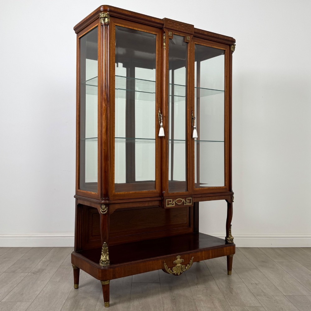 A nineteenth-century French mahogany glazed display cabinet featuring gilt-bronze mounts, glass shelving, and an open lower tier. View IX