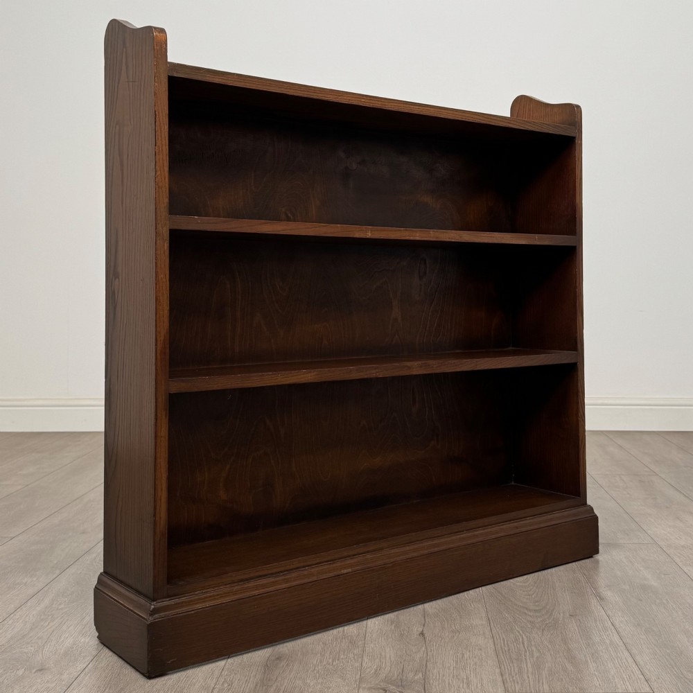 A twentieth-century dark oak open bookcase with three fitted shelves and profiled side edges. View IX